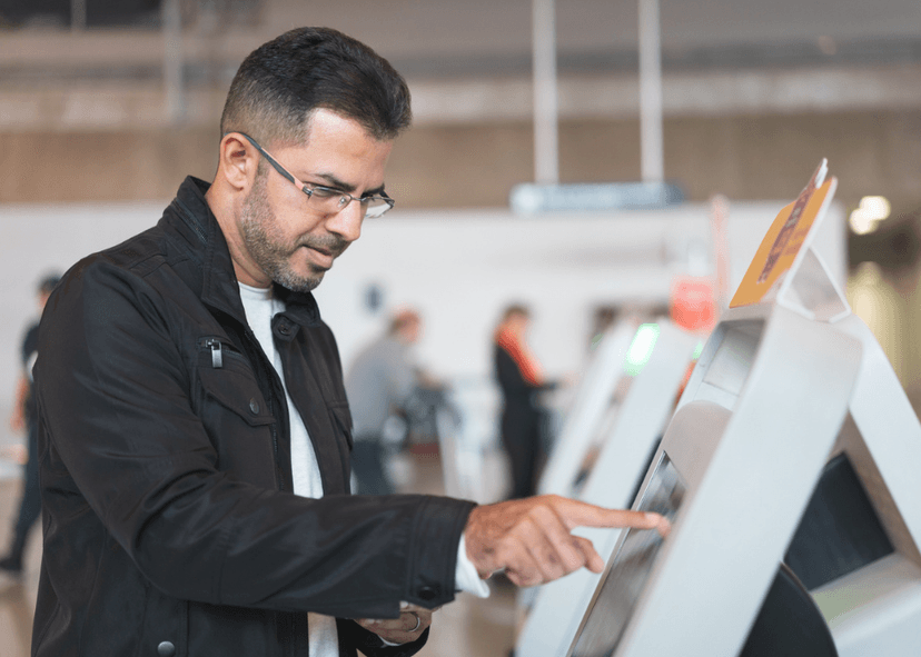 man looking at information screen at airport