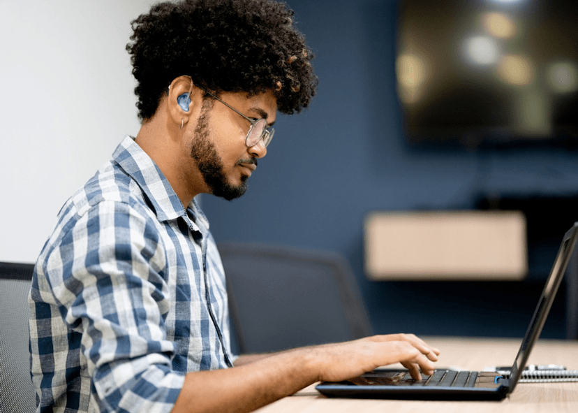 Man with hearing aid with laptop